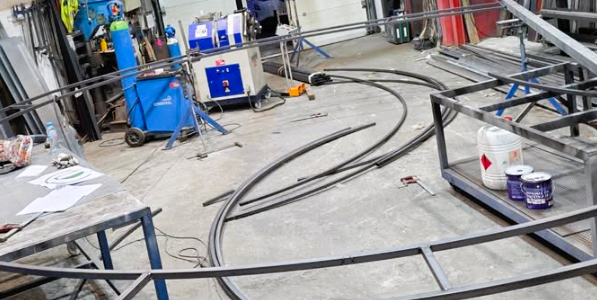 Màquina Corbadora de Tubs i Perfils fabricada en acer, arrossegament als tres corrons, transmissió per pinyons, eixos tractats i rectificats. Amb això podem treballar qualsevol ferro i donar-li la forma que ens demanin.